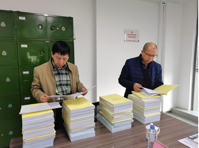 自治区档案局测评组专家在查看资料.png